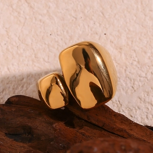 Vue macro d'une bague géométrique en acier inoxydable plaqué or 18 carats sur bois