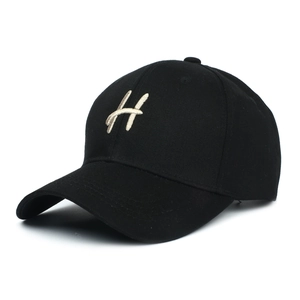 Gros plan de la broderie lettre H blanche sur une casquette de baseball noire à six pans