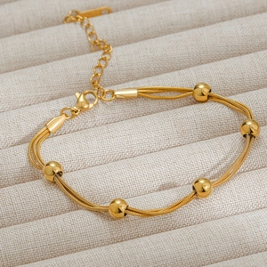 Three-strand golden stainless steel snake chain bracelet with polished bead accents