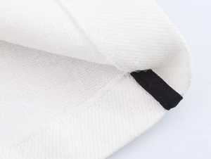 Detail showing high-density knitted texture and contrast black trim stitching on white dress