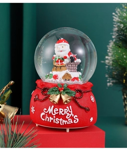 Close-up of Santa Claus in glass snow globe with red Merry Christmas resin base