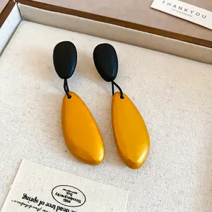 Irregular wooden teardrop earrings with black oval stud in jewelry display box