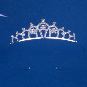 Dettaglio di tiara argentata con strass a farfalla su sfondo in tessuto blu scuro