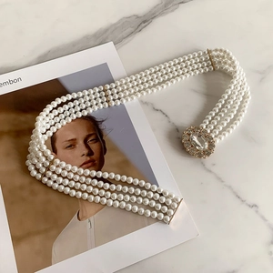 Detail of four-layer pearl chain with vintage gold buckle and sparkling rhinestone inlay