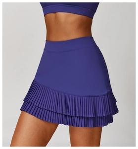 Detail of high-waisted pleated sports skirt showing tiered asymmetric layers in dark purple