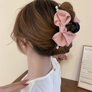 Detailed back view of pink satin ribbon bow hair claw with sparkling rhinestones decoration
