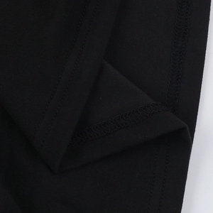 Dettaglio delle cuciture in rete nera e dell'orlo su questo abito elegante con spalle scoperte