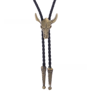 Detail of western cow skull bolo tie with vintage bronze pendant and woven leather cord