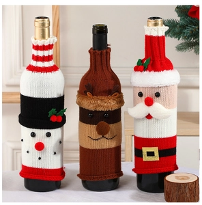 Close-up of knitted Christmas wine bottle covers featuring Santa, snowman and reindeer