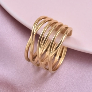 Detailed close-up of a gold multi-layer cutout ring on elegant pink silk and ceramic tray