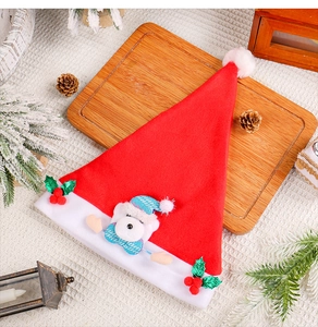 Christmas hat detail featuring a cute bear doll and holly leaf decor on wooden board