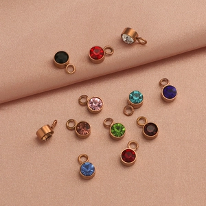Detail of round colorful birthstone charms set in gold metal frames for DIY jewelry