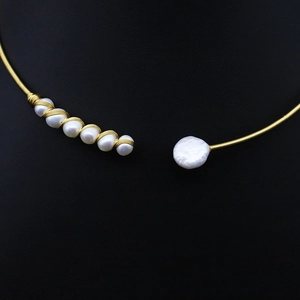 Minimalist freshwater pearl choker necklace with gold wire wrap for women in black background