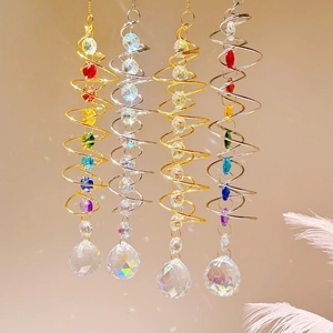 Close-up of four crystal suncatchers with gold and silver metal spiral frames and beads