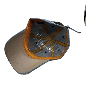 Inside view of denim baseball cap with orange trim and adjustable strap detail