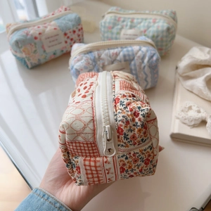 Close-up of quilted floral cotton makeup bag with metal zipper and soft fabric texture