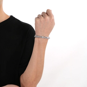 Détail du bracelet de motard en argent avec boucle carrée vintage sur le poignet d'homme