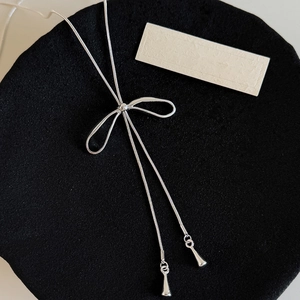 Dettaglio della collana con fiocco d'argento con catena a serpente ed eleganti nappe a goccia