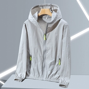 Détail de veste de protection solaire gris clair avec tirette vert fluo et capuche