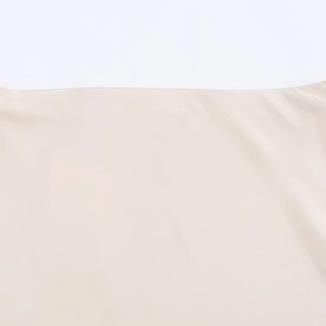 Gros plan sur un tissu en satin de soie beige avec coutures lisses et texture fine