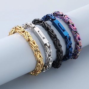 Detailed view of heavy Byzantine chain bracelets in gold, silver, and black stainless steel