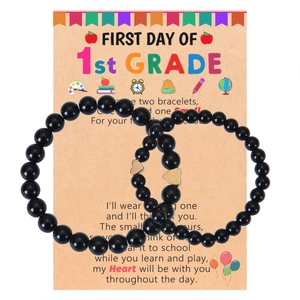 Two black beaded bracelets with gold heart charms on a First Day of School card