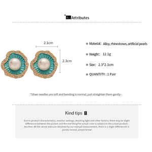 Vue détaillée de la boucle d'oreille pétoncle avec émail bleu, cristaux et perle