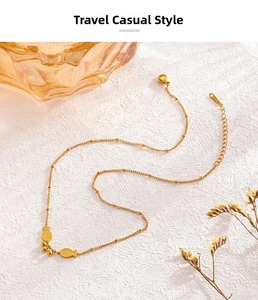 Close-up of golden stainless steel fish pendant necklace with textured scales details