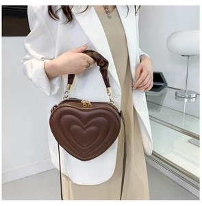 Detail of dark brown heart-shaped PU leather bag with unique pleated handle and zipper