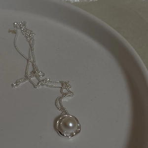 Detail of S925 sterling silver necklace featuring a fresh water pearl with irregular frame