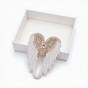 Elegant angel wing brooch with white enamel and diamonds in a minimalist jewelry gift box