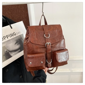 Détail d'un sac à dos vintage en cuir PU marron avec sangles à boucle et rivets en métal
