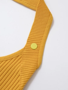 Detail of yellow ribbed knit fabric with a fluorescent green resin button closure
