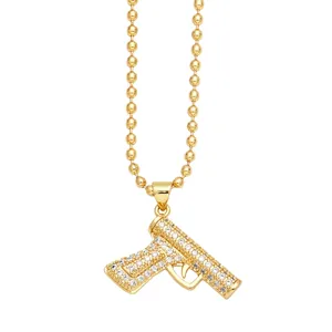 Detailed macro view of gold-plated machine gun pendant with shiny paved crystals