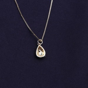 Collana dorata con ciondolo a goccia traforato e zirconi colorati brillanti