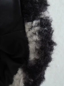 Macro detail of windproof black inner lining and plush black and white checkered faux fur trim