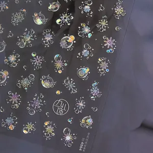 Macro detail of holographic snowflake and bubble nail art decals with shell luster effect