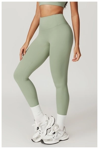Detail of high waist sage green yoga leggings with matching sports bra on a model