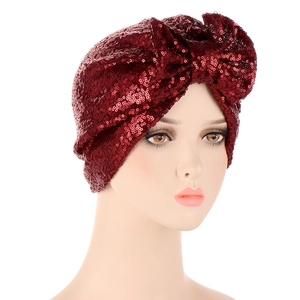 Detail of burgundy sequin turban hat with a large bow on a mannequin head display