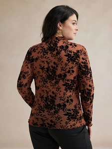 Détail du haut en tulle à col montant avec flocage floral en velours noir sur brun foncé