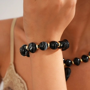 Detailed shot of black marble acrylic beads and gold spacers on a vintage sweater necklace