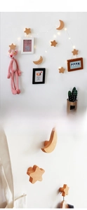 Macro detail of star and moon shaped solid wood wall hooks with natural grain texture