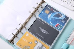 Macro detail of transparent PVC 3-slot card holder insert in mint green binder