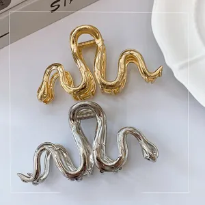 Detail shot of gold and silver metal hair claws with elegant snake scale texture