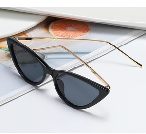 Detail view of cat eye sunglasses with black resin frame and slim gold metal temples