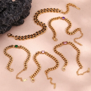 Macro detail of 18K gold plated Cuban chain bracelet with purple and green zircon stones
