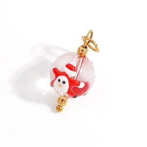 Detail view of a Christmas crystal ball pendant with Santa Claus figure and golden clasp