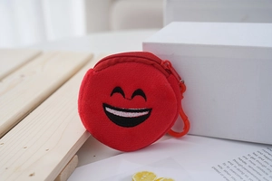 Close-up of red plush coin purse with embroidered smile and plastic hanging hook