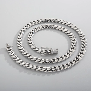 Macro shot of silver Cuban link necklace featuring a diamond-encrusted square clasp