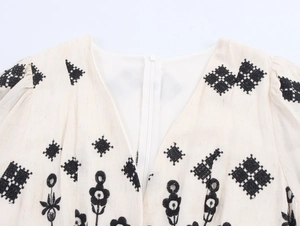 Detail of V-neck embroidery and hidden zipper on a bohemian linen maxi dress